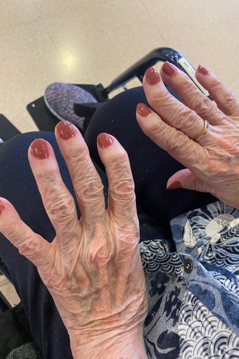 Red round nails, older hands with bracelets