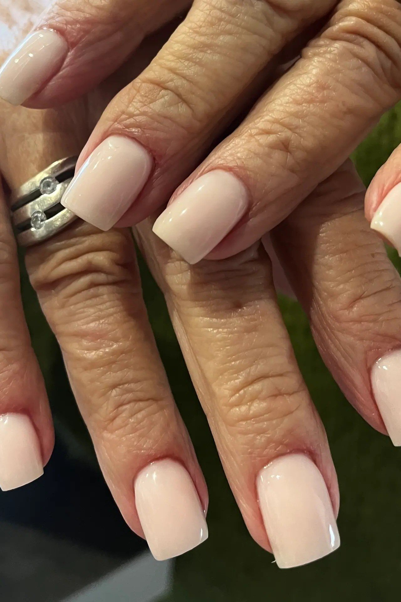 Nude square nails, mature hands close-up with rings