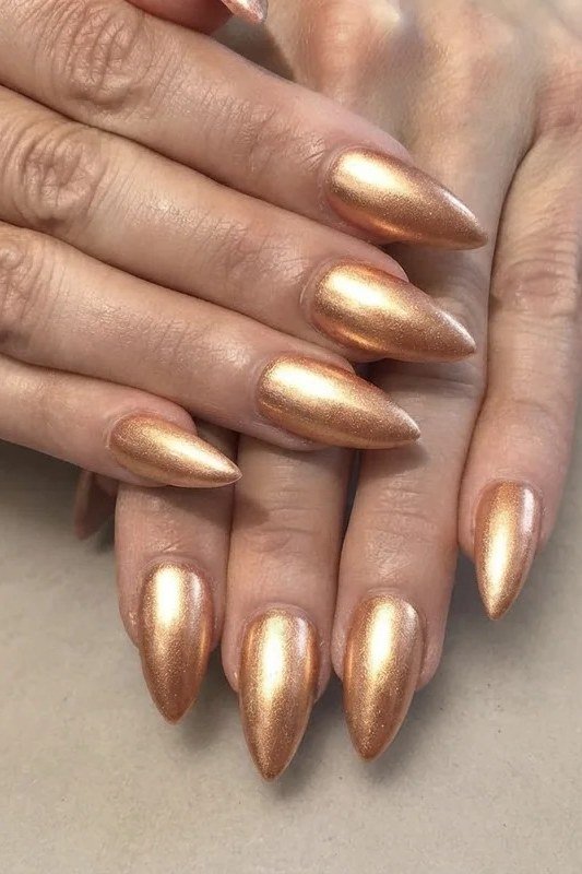 Gold chrome stiletto nails, mature hands
