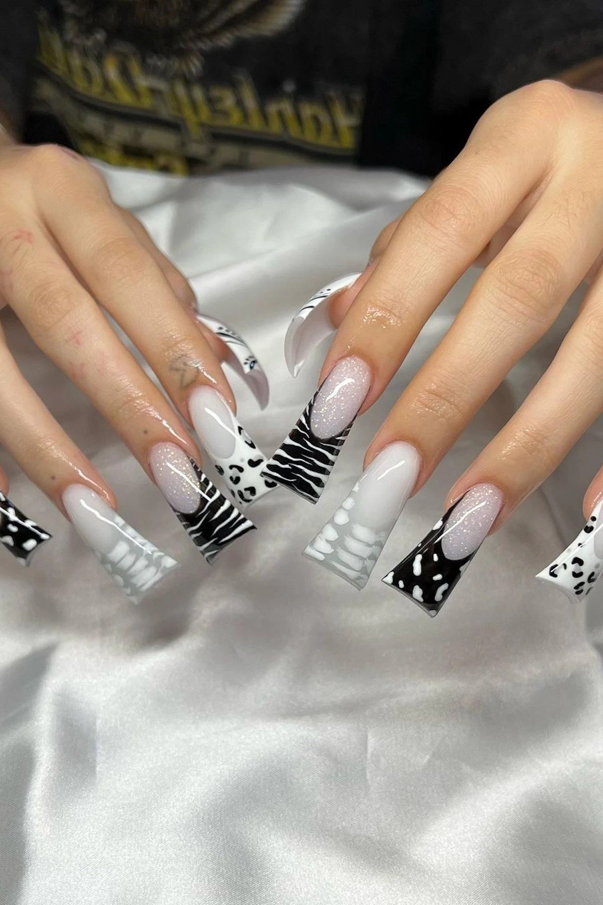 White coffin nails with black art, mature hands