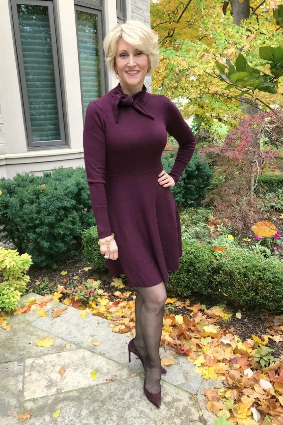 Woman over 40 wearing a plum shirt dress with sheer tights