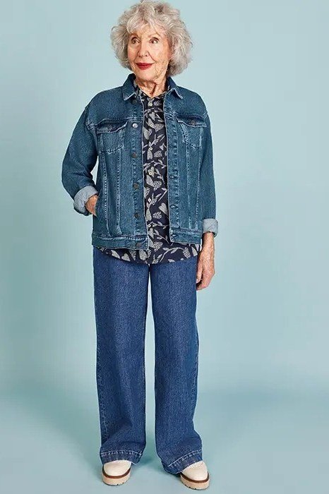 Denim jacket with patterned blouse and wide jeans, classic casual outfit for women over 60