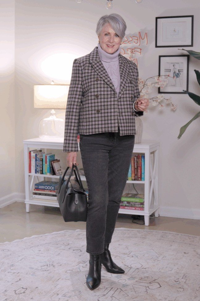 october outfits for women over 60: woman over 60 wearing houndstooth blazer, gray jeans and black ankle boots indoors
