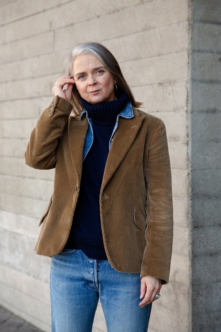 october outfits for women over 60: woman over 60 in brown corduroy blazer over navy turtleneck with jeans