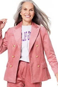 october outfits for women over 60: woman over 60 in pink corduroy suit with white graphic tee in studio