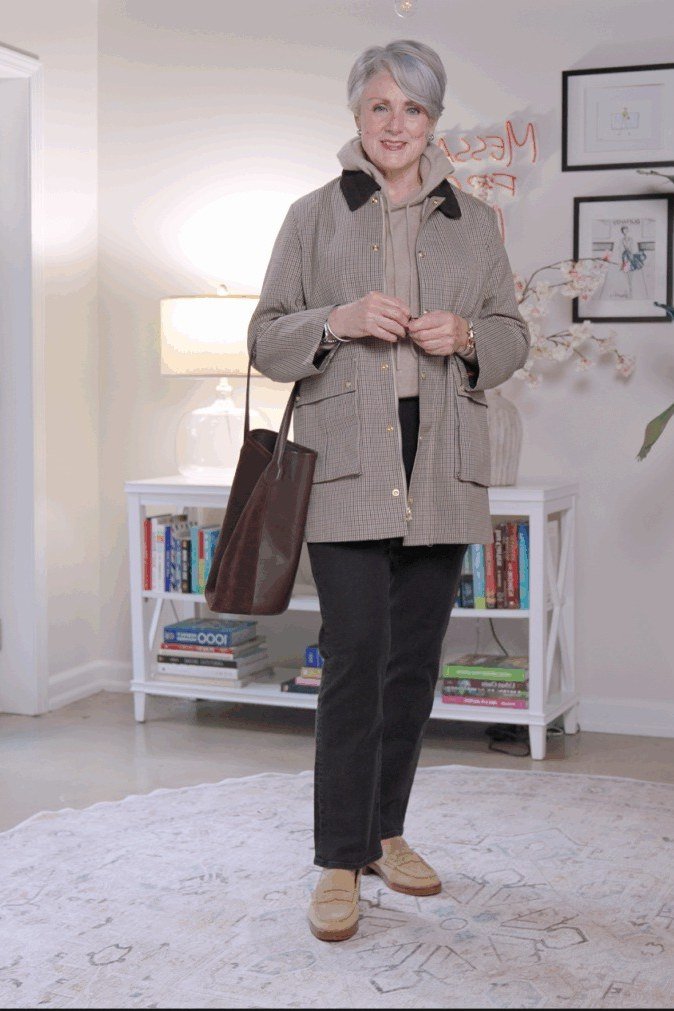 october outfits for women over 60: woman over 60 in gray checkered shacket over dark pants with brown bag indoors