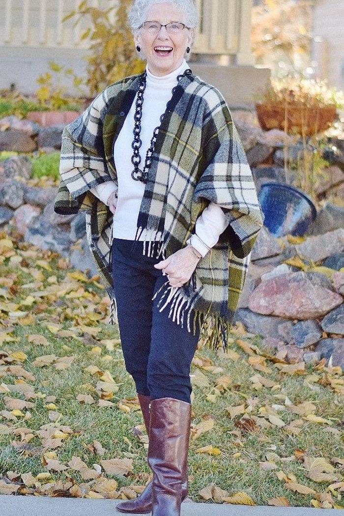 Trendy outfit for women over 70: plaid poncho + dark jeans + brown boots