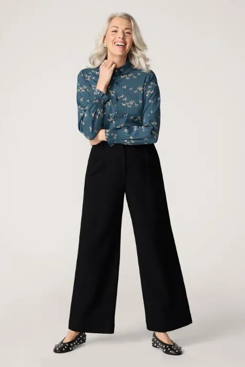 Trendy outfit for women over 70: teal floral blouse + black wide-leg