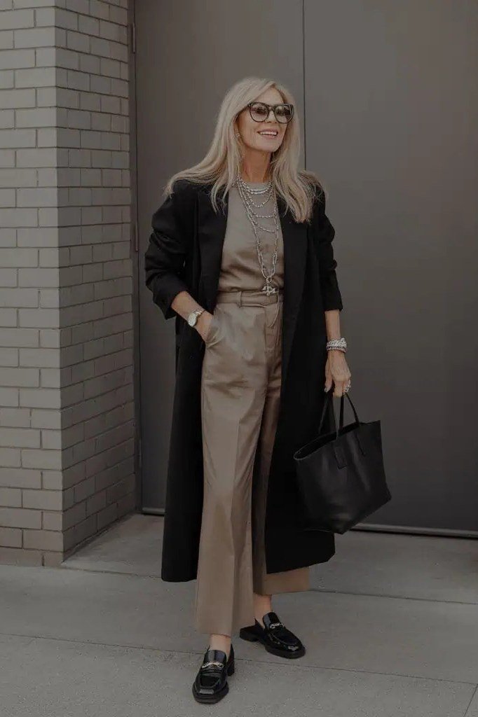 Trendy outfit for women over 70: black coat + beige jumpsuit