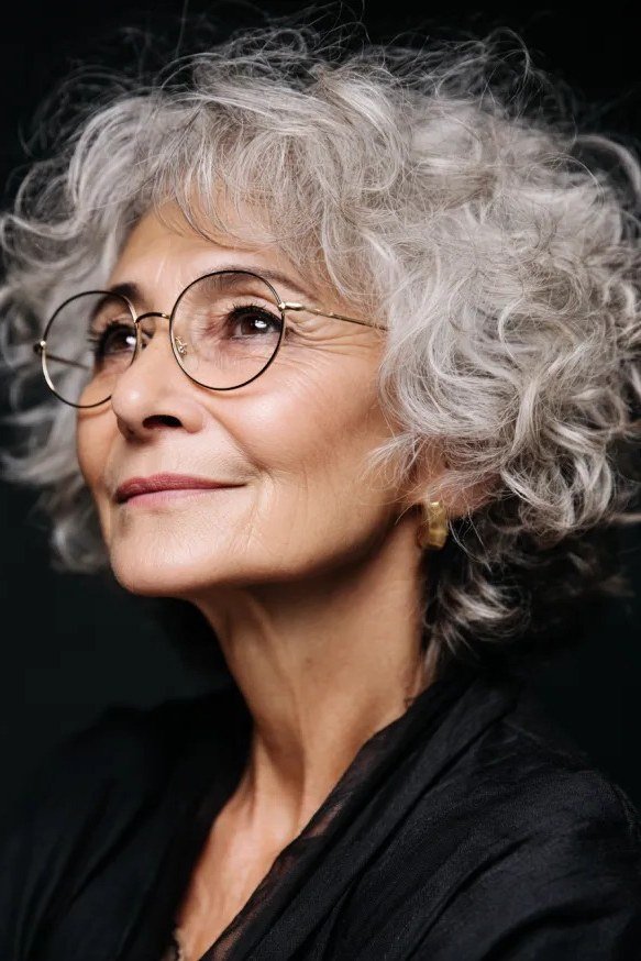 Curly grey pixie with round glasses - pixie haircut for women over 60