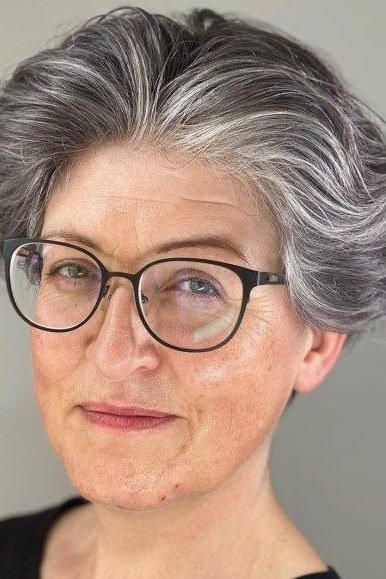 Salt and pepper pixie with black glasses, front view - pixie haircut for women over 60