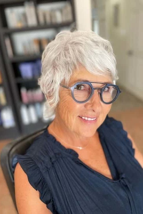 White curly pixie with blue glasses, salon setting - pixie haircut for women over 60