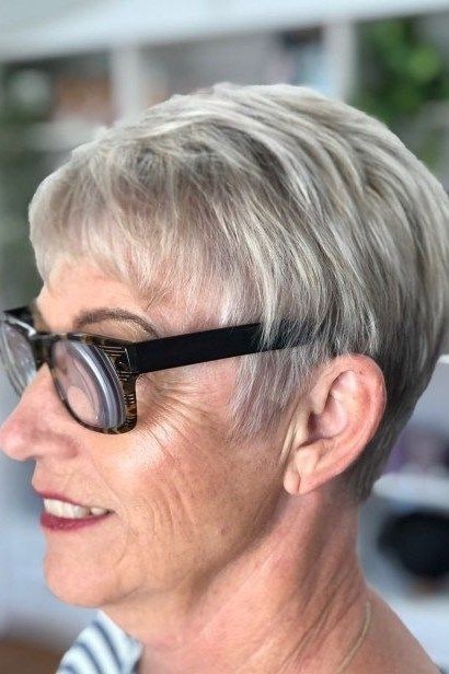 Grey pixie with black glasses, side view smiling - pixie haircut for women over 60