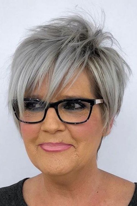 Spiky silver pixie haircut with bold texture and black glasses