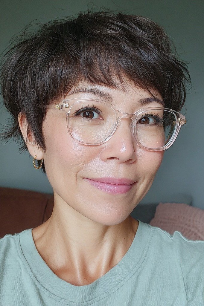 Dark chocolate brown pixie haircut with round glasses