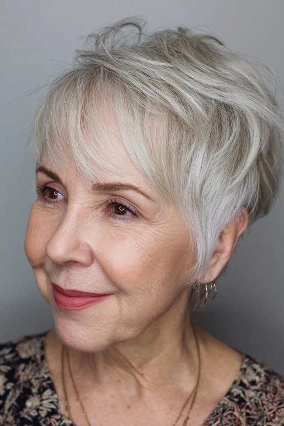 Silver pixie haircut with soft side swept bangs for older women