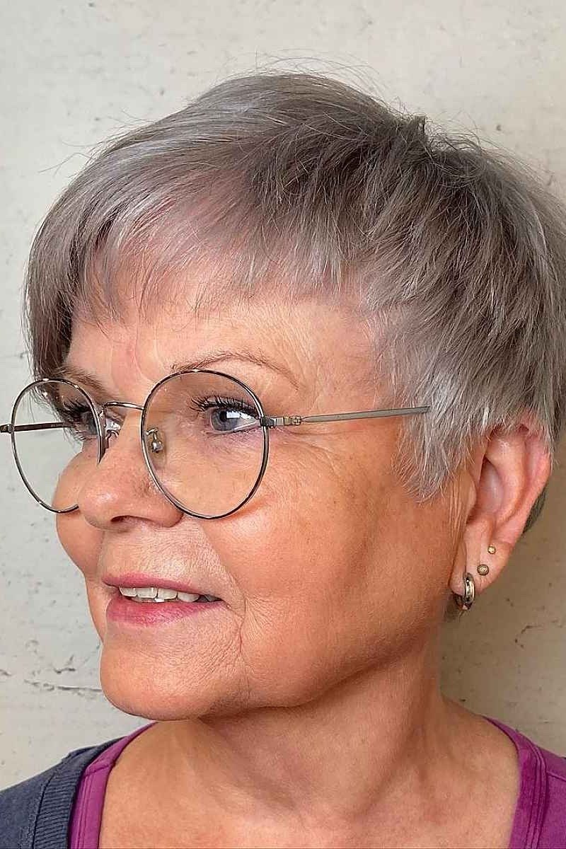 Silver pixie haircut with rounded bangs and glasses for older women
