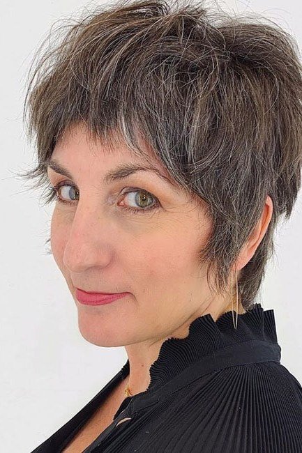 Dark shaggy pixie haircut with choppy bangs for women over 60