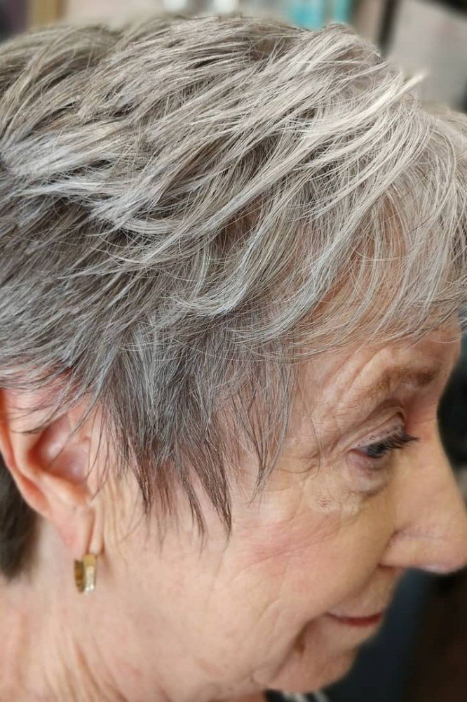 Grey pixie haircut with soft side swept bangs, side view, for older women