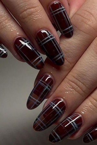 Deep burgundy and black plaid nails in almond shape with glossy finish