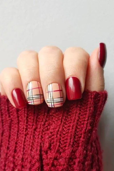 Cherry red nails with beige plaid accents and red knit sweater
