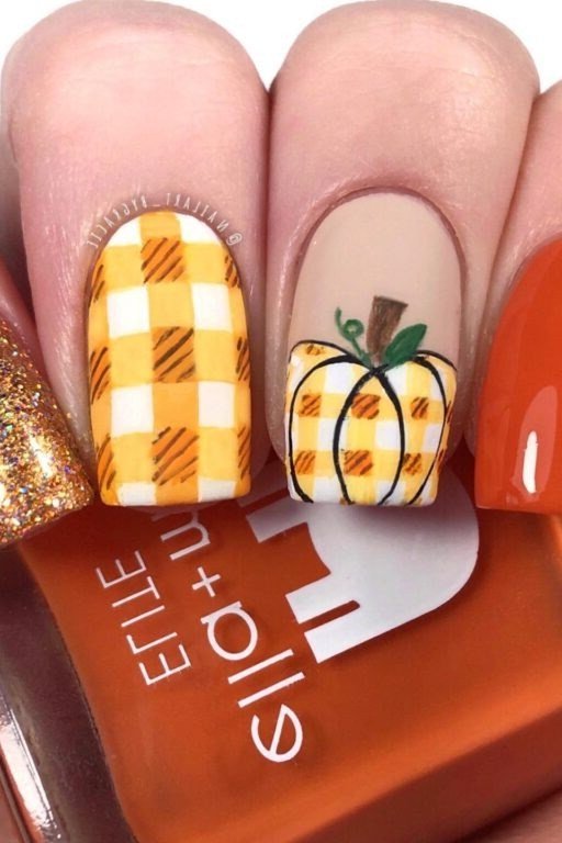 Gold glitter nails with pumpkin gingham accent nail