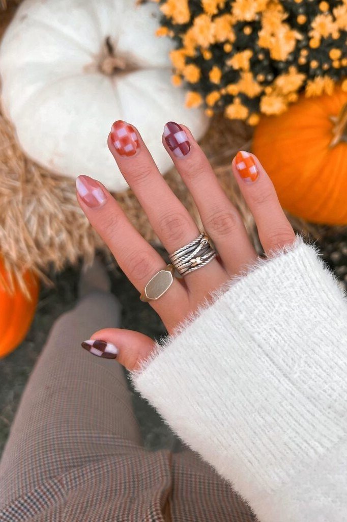 Pink and orange plaid nails with white sweater