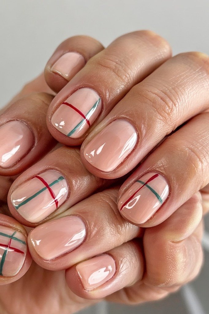 Nude nails with thin red and green plaid lines