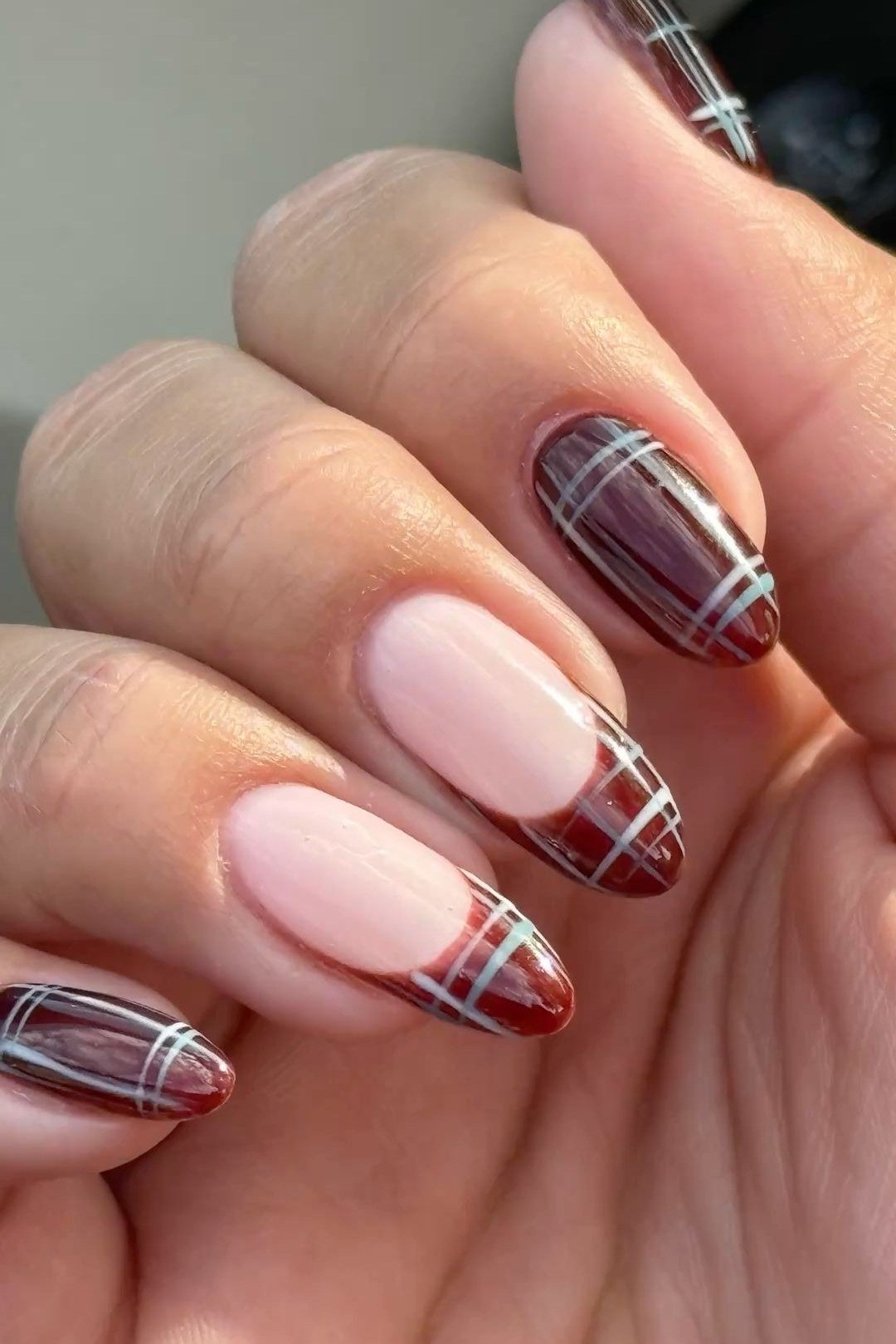 Burgundy plaid french tip nails on almond nails