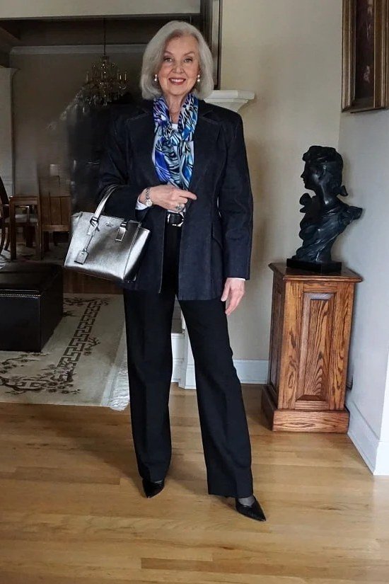 plus-size woman over 60 wearing black blazer with blue patterned scarf and trousers