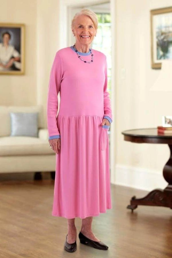 plus-size older woman wearing soft pink fit-and-flare midi dress with beaded necklace