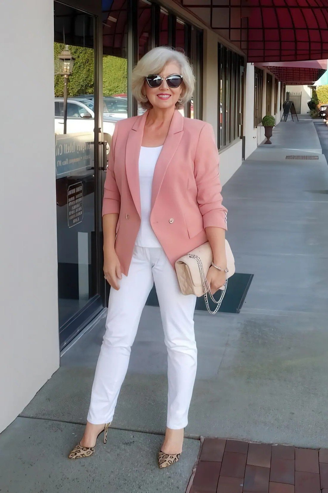 plus-size woman over 60 wearing coral blazer with white top and white jeans on street