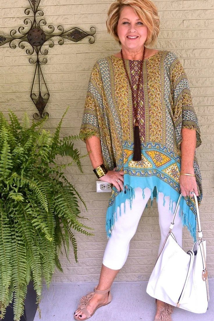 plus-size older woman wearing turquoise and yellow patterned tunic with white capri pants on patio