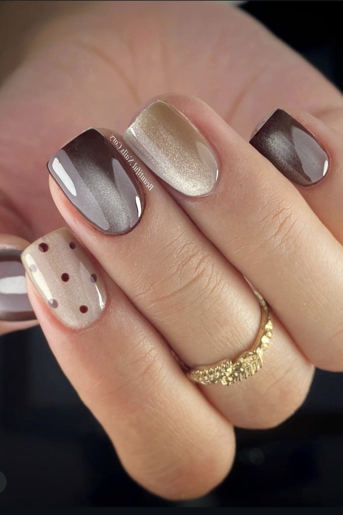 Copper cat-eye almond nails with white polka dots close up, fall cat-eye nail art