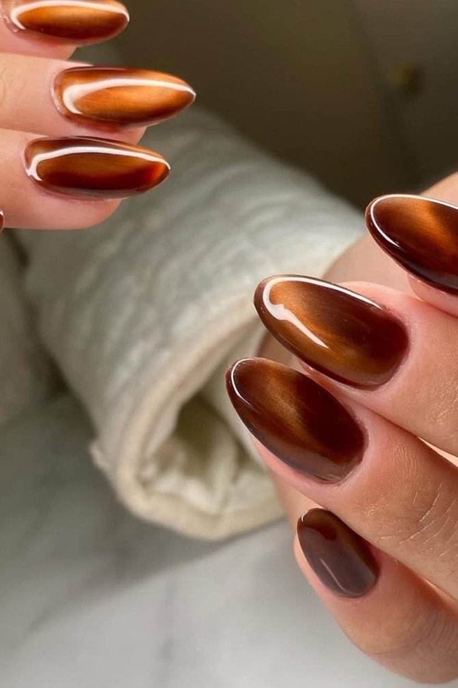 Amber chocolate cat-eye almond nails with white polka dots, fall nail design