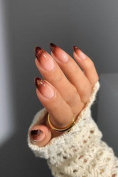 Burgundy glitter ombre French almond nails with white polka dots and cream knit sleeve