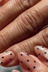 Soft nude nails with tiny white polka dots on mature hands, elegant fall nails for women over 50