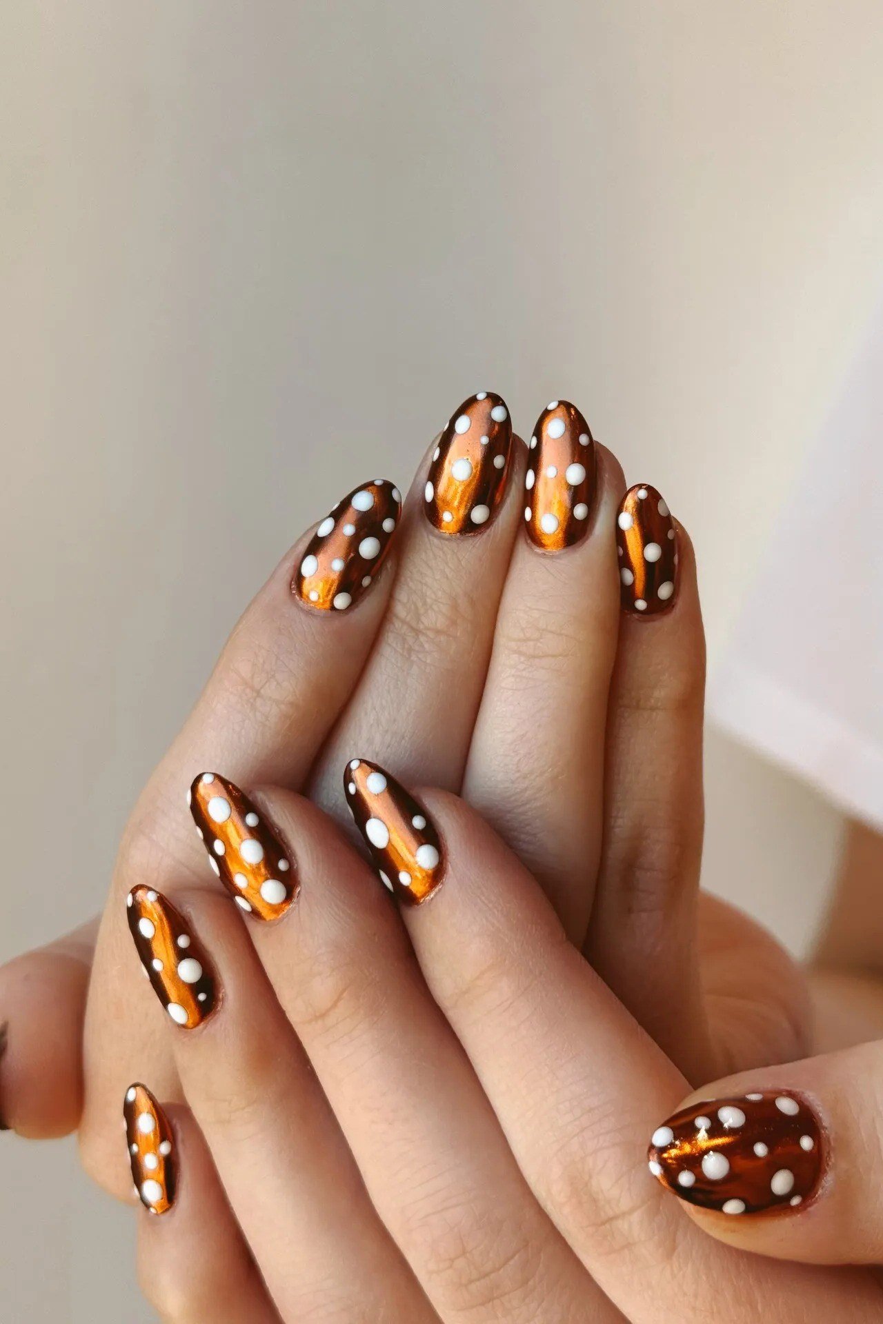 Burnt orange and black short nails with reversed polka dots, fun fall nail design