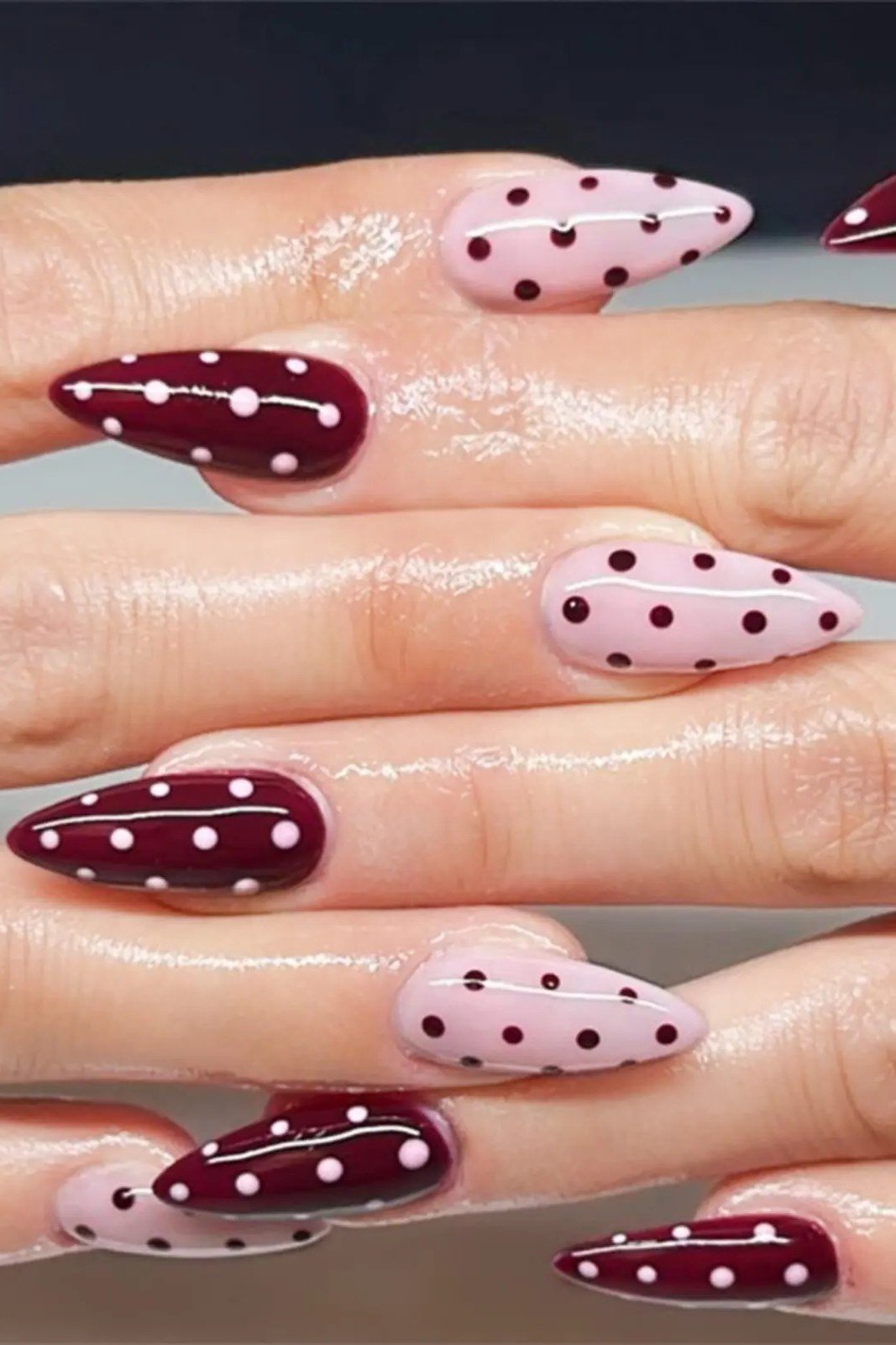 Oxblood stiletto nails with pink polka dot accent nails, bold fall nail design