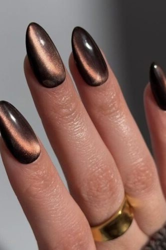 Copper cat-eye almond nails with a simple gold ring, fall nail design