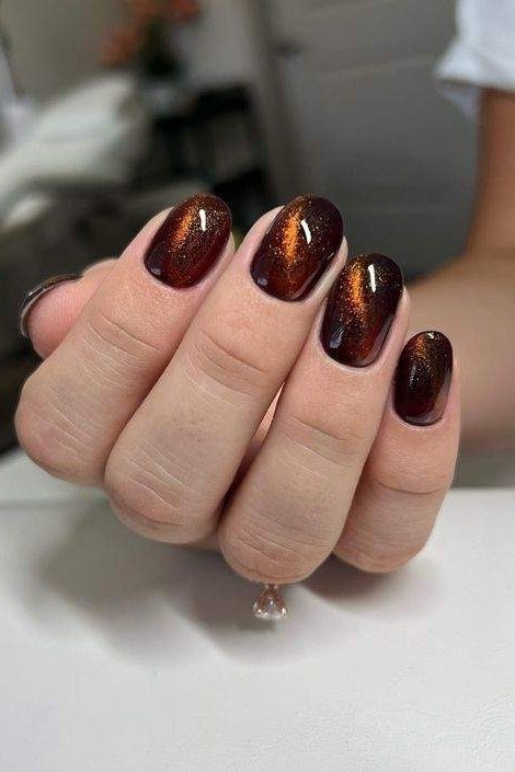Copper cat-eye almond nails with white polka dots, warm fall nail art