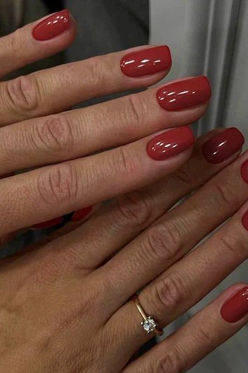 Mature crossed hands with burgundy nails and a diamond ring