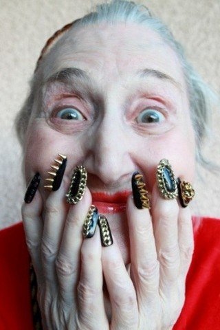 Elderly woman making a funny face with decorated black-and-gold nails