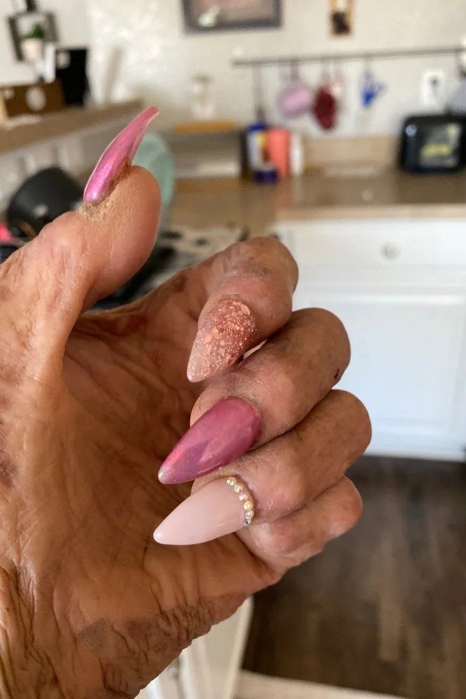 Mature hand with long pink stiletto and ombre almond press-ons