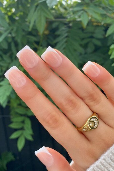Classic French-tip press-on nails shown outdoors