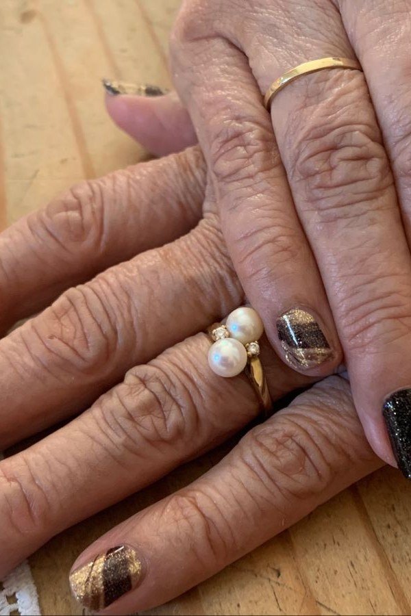 Mature hands with animal-stripe brown press-ons and rings
