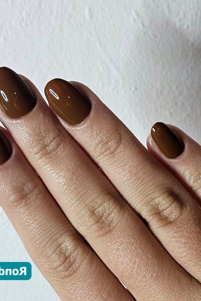 Glossy chocolate-brown press-on nails on a hand
