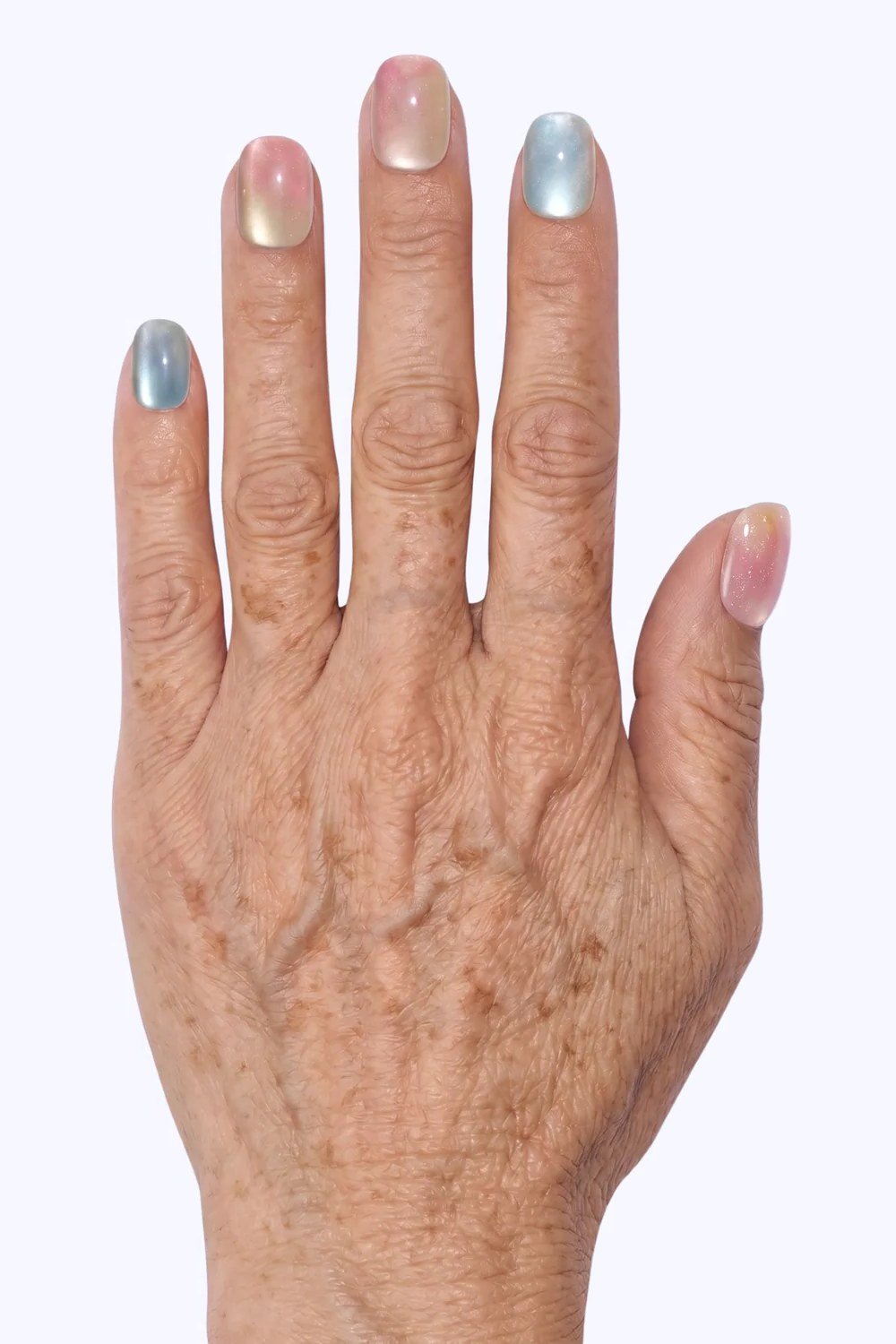 Mature hand with pearly pastel press-on nails