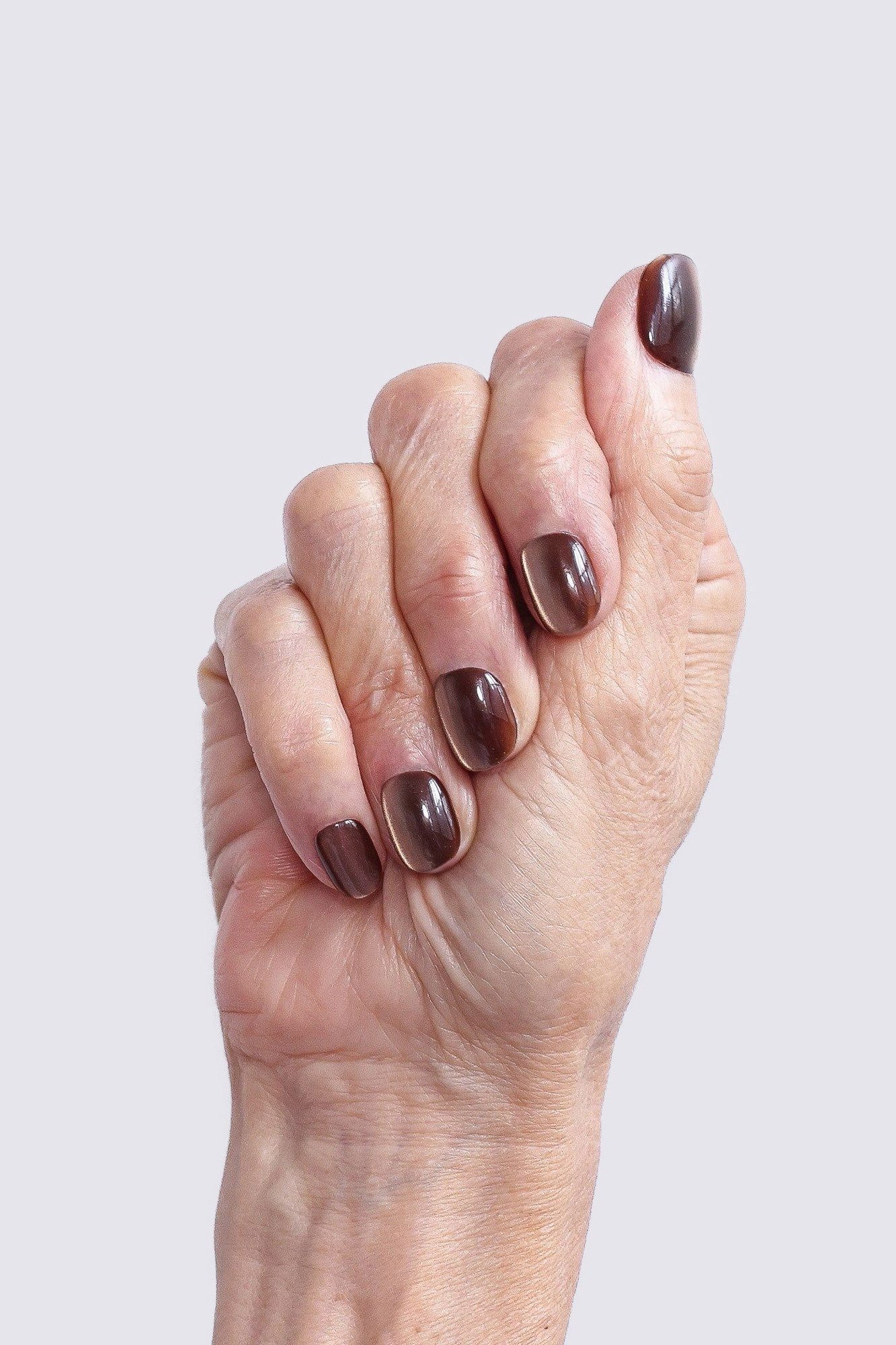 Mature hand with glossy chocolate-brown nails