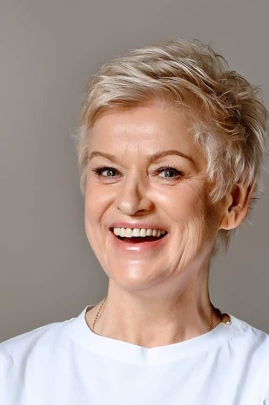 Bright blonde pixie for older women, laughing short crop